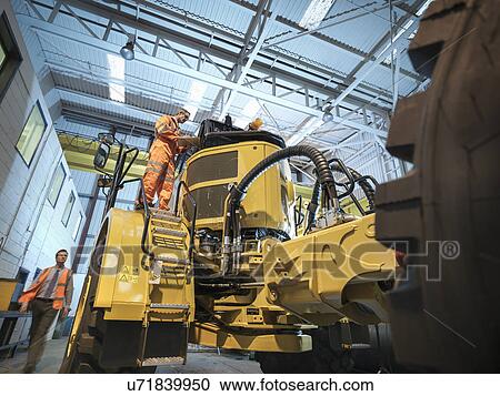 Engineers inspecting earth moving truck, low angle view View Large Photo Image Stock Image - Engineers inspecting earth moving truck, low angle view. Fotosearch