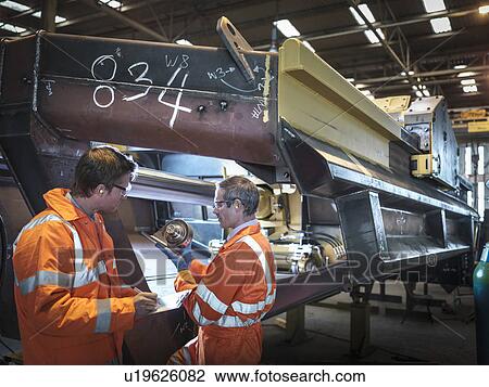 Engineers inspecting steel components in factory View Large Photo Image Stock Image - Engineers inspecting steel components in factory. Fotosearch