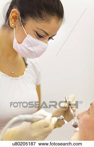 Female dentist working on patient View Large Photo Image Stock Photo - Female dentist working on patient. Fotosearch