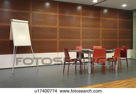 Picture - Flipchart and red chairs in conference room. Fotosearch