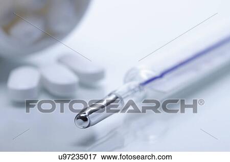 Stock Photo - Galinstan thermometer and acetaminophen pills. Fotosearch