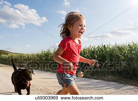 Girl and dog running through field View Large Photo Image Stock Photo - Girl and dog running through field. Fotosearch