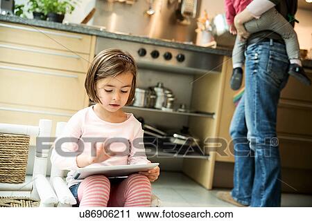 Girl using digital tablet in kitchen View Large Photo Image Stock Image - Girl using digital tablet in kitchen. Fotosearch