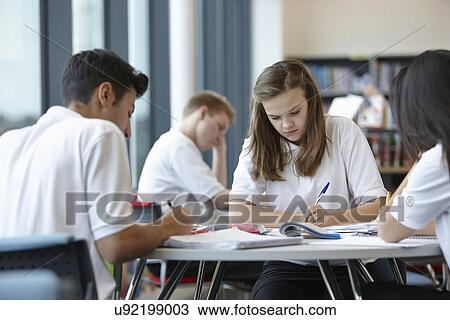 Stock Image - Group of teenagers working in school class. Fotosearch