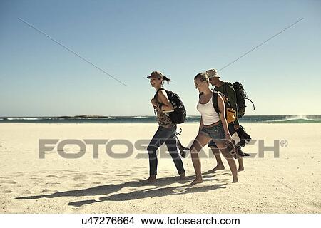 Group of young adult friends walking on beach, Cape Town, South Africa View Large Photo Image Picture - Group of young adult friends walking on beach, Cape Town, South Africa. Fotosearch