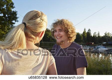 Stock Photo - Happy young couple in conversation, Gavle, Sweden. Fotosearch