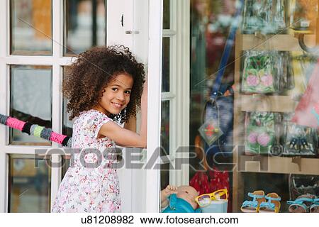 Happy young girl standing outside shop View Large Photo Image Stock Image - Happy young girl standing outside shop. Fotosearch