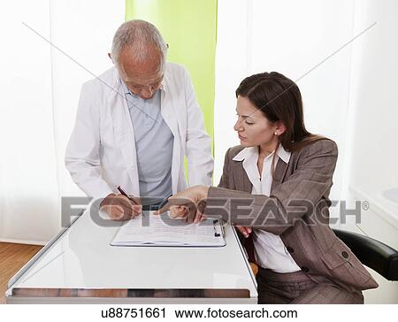 Stock Image - Healthcare professionals discussing medical records. Fotosearch