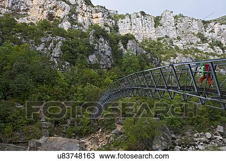 Hiker on hanging footbridge over the Verdon canyon, Provence, France View Large Photo Image Stock Image - Hiker on hanging footbridge over the Verdon canyon, Provence, France. Fotosearch