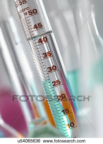 Stock Photograph - Laboratory glassware in lab, Measuring flasks and cylinders containing chemicals during experiment. Fotosearch