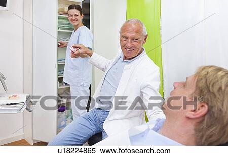 Male dentist treating male patient View Large Photo Image Stock Photography - Male dentist treating male patient. Fotosearch