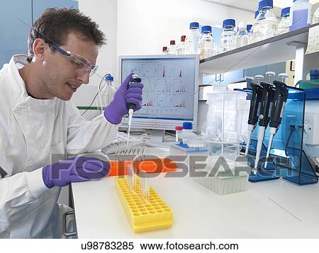 Stock Photography - Male scientist pipetting sample into test tubes for analysis of cell population. Fotosearch