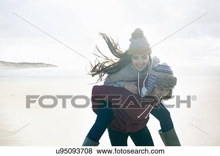 Man giving woman piggy back, Brean Sands, Somerset, England View Large Photo Image Stock Photo - Man giving woman piggy back, Brean Sands, Somerset, England. Fotosearch