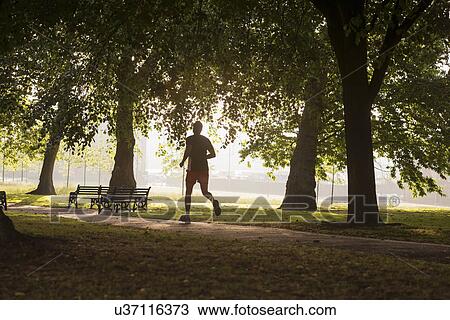 Stock Image - Man jogging in park. Fotosearch