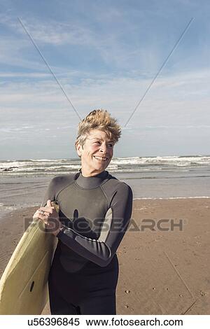 Stock Photography - Mature female bodyboarder on Devon beach, UK. Fotosearch