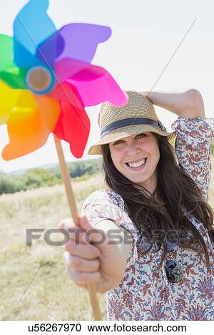 Mid adult woman holding windmill View Large Photo Image Stock Image - Mid adult woman holding windmill. Fotosearch