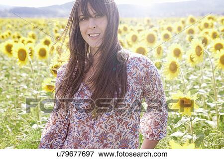 Mid adult woman in field of sunflowers View Large Photo Image Stock Photo - Mid adult woman in field of sunflowers. Fotosearch