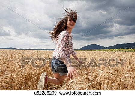 Mid adult woman running through wheat field View Large Photo Image Stock Photo - Mid adult woman running through wheat field. Fotosearch