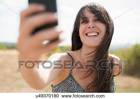 Mid adult woman taking self portrait photograph View Large Photo Image Stock Image - Mid adult woman taking self portrait photograph. Fotosearch