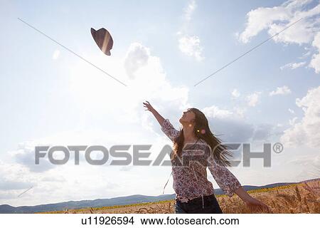 Mid adult woman throwing hat in air View Large Photo Image Picture - Mid adult woman throwing hat in air. Fotosearch