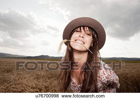 Mid adult woman with wheat in her mouth View Large Photo Image Stock Photo - Mid adult woman with wheat in her mouth. Fotosearch