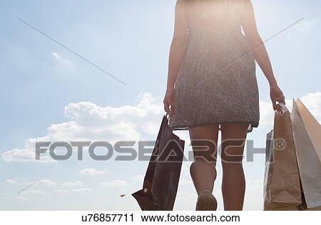Mid section of woman carrying shopping bags View Large Photo Image Stock Image - Mid section of woman carrying shopping bags. Fotosearch