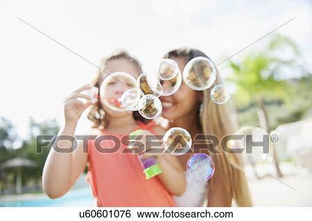 Mother and daughter blowing bubbles View Large Photo Image Stock Photograph - Mother and daughter blowing bubbles. Fotosearch