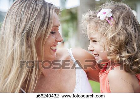 Stock Image - Mother and daughter hugging, face to face. Fotosearch