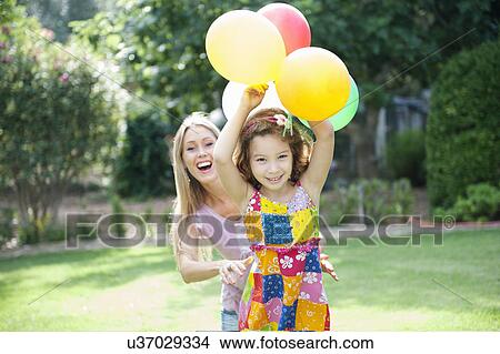 Picture - Mother and daughter in garden with balloons. Fotosearch