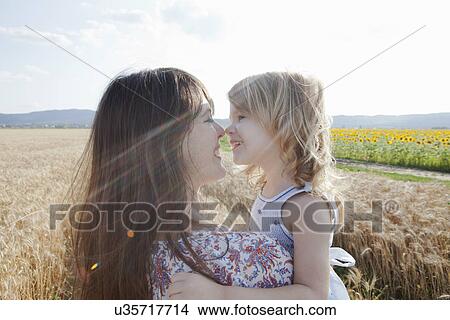Picture - Mother and daughter in wheat field hugging. Fotosearch