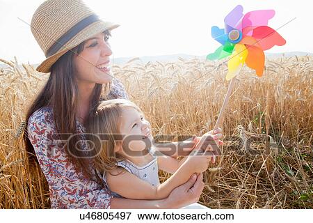 Mother and daughter in wheat field holding windmill View Large Photo Image Stock Photo - Mother and daughter in wheat field holding windmill. Fotosearch