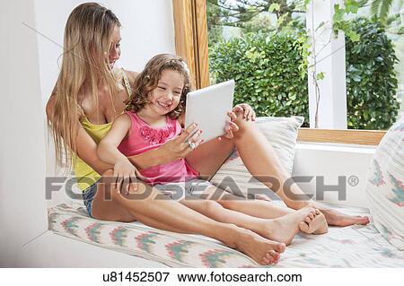 Mother and daughter using digital tablet View Large Photo Image Stock Photo - Mother and daughter using digital tablet. Fotosearch