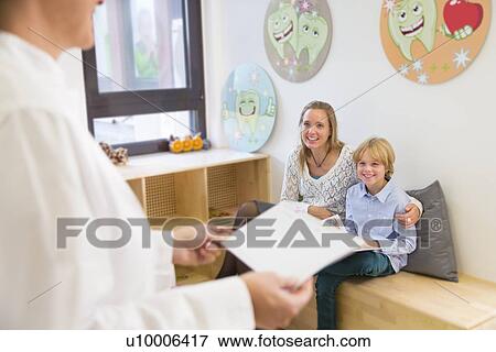 Stock Photo - Mother and son in dentists waiting room. Fotosearch