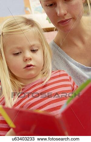 Mother reading picture book with daughter View Large Photo Image Stock Image - Mother reading picture book with daughter. Fotosearch