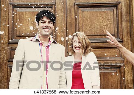 Stock Photo - Newly married couple in confetti shower. Fotosearch