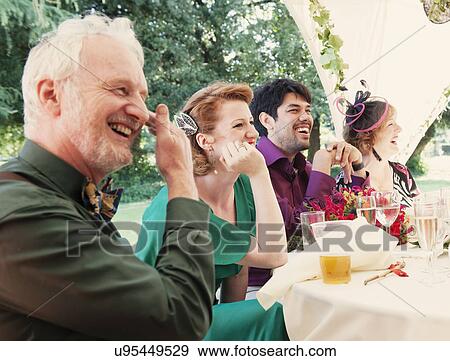 Stock Photo - Newly married couple with parents at wedding reception. Fotosearch