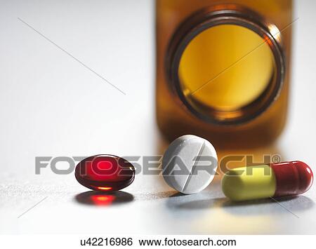 Pain killers pouring from brown medicine bottle View Large Photo Image Stock Photograph - Pain killers pouring from brown medicine bottle. Fotosearch