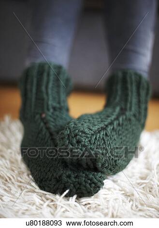 Stock Image - Pair of feet in green knitted socks. Fotosearch