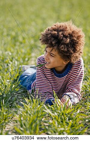 Portrait of boy lying on grass in sunlight View Large Photo Image Picture - Portrait of boy lying on grass in sunlight. Fotosearch