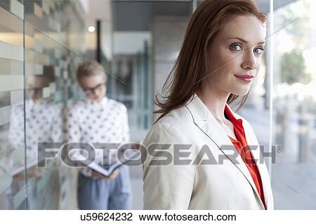 Portrait of businesswoman with colleague in background View Large Photo Image Stock Image - Portrait of businesswoman with colleague in background. Fotosearch