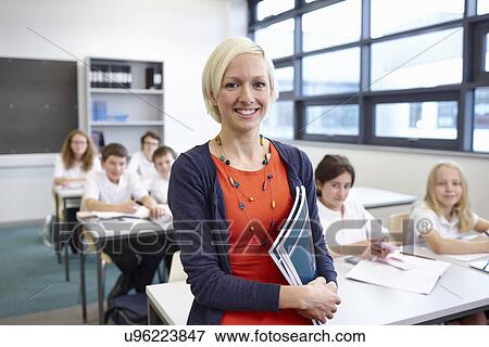 Stock Photo - Portrait of female teacher with class. Fotosearch