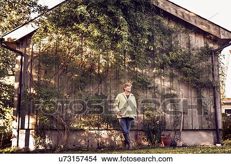 Picture - Portrait of happy mature woman in garden. Fotosearch