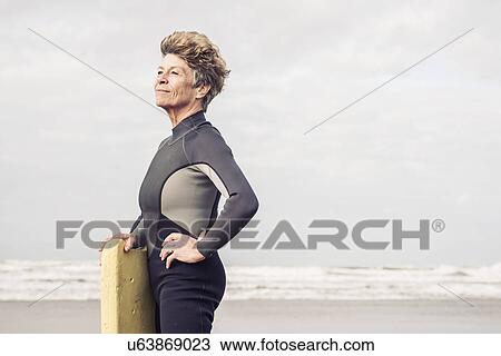 Stock Image - Portrait of mature female bodyboarder, Devon, UK. Fotosearch