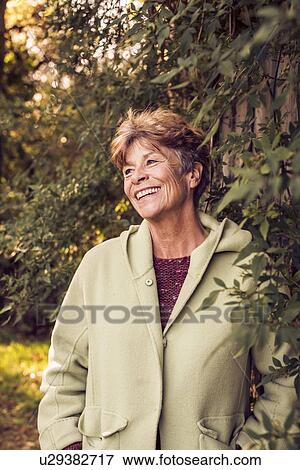 Stock Photo - Portrait of mature woman in garden. Fotosearch