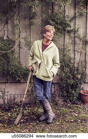 Portrait of mature woman leaning on spade in garden View Large Photo Image Picture - Portrait of mature woman leaning on spade in garden. Fotosearch
