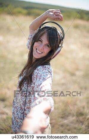 Portrait of mid adult woman dancing in field with arms raised, wearing headphones View Large Photo Image Stock Photo - Portrait of mid adult woman dancing in field with arms raised, wearing headphones. Fotosearch