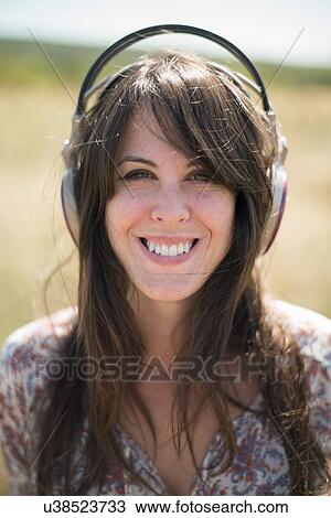 Portrait of mid adult woman wearing headphones View Large Photo Image Stock Image - Portrait of mid adult woman wearing headphones. Fotosearch