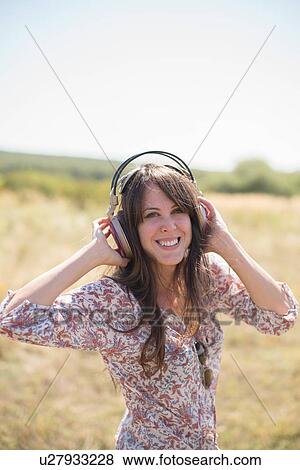 Portrait of mid adult woman wearing headphones View Large Photo Image Stock Photo - Portrait of mid adult woman wearing headphones. Fotosearch