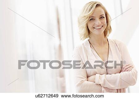 Portrait of mid adult woman with arms crossed View Large Photo Image Stock Photo - Portrait of mid adult woman with arms crossed. Fotosearch