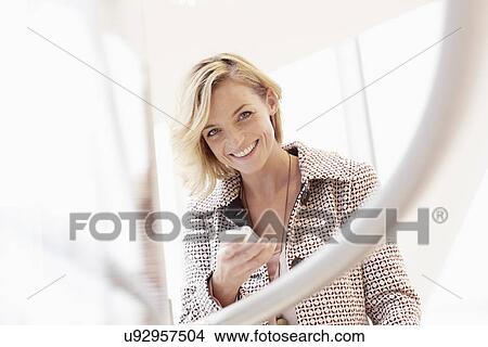 Picture - Portrait of mid adult woman with mobile phone. Fotosearch